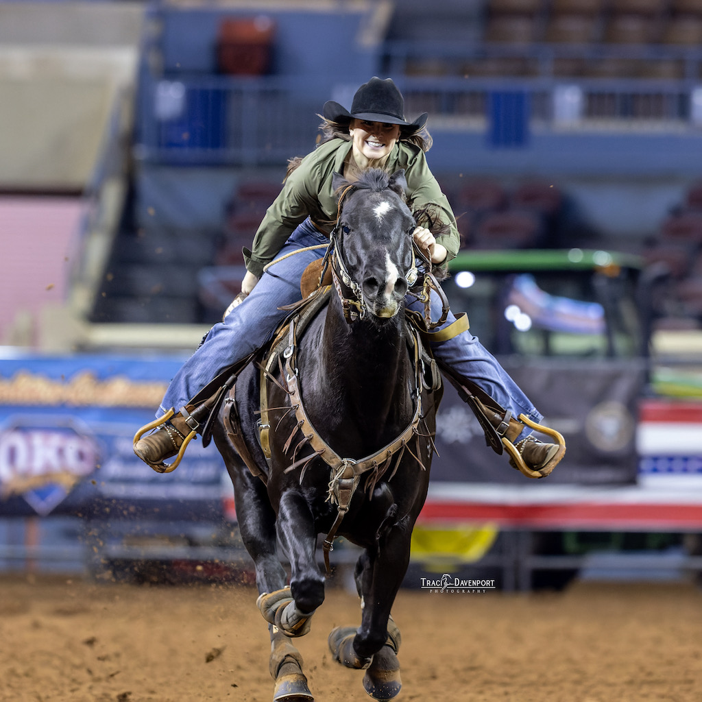 smiling-woman-on-black-horse-running-toward-the-camera-for-a-blog-about-lessons-from-the-rodeo-circuit