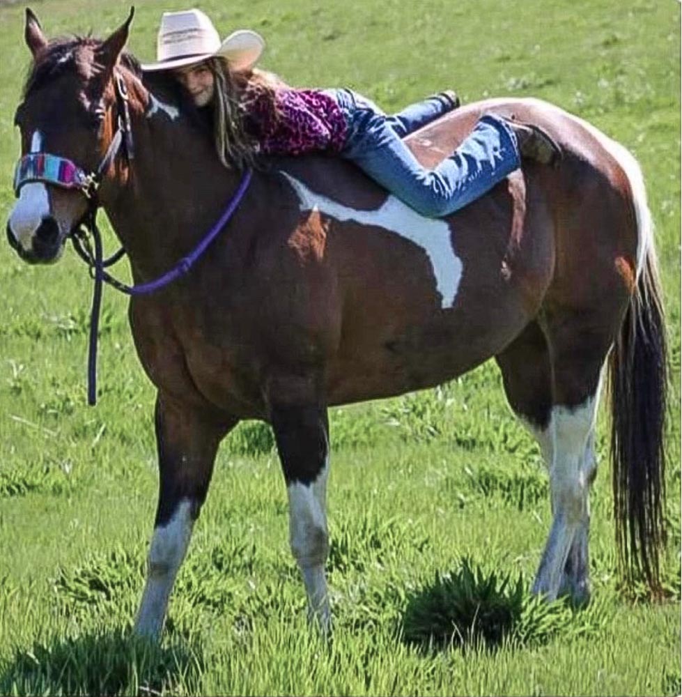 young-girl-in-white-cowboy-hat-laying-on-the-bareback-of-a-paint-horse-with-ways-to-keep-a-grateful-heart